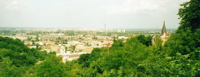 Панорама Подолу з вершини Замкової гори влітку, з баштою замку Річарда Левове Серце праворуч серед зелені.